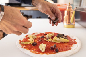 Staff member making a pizza